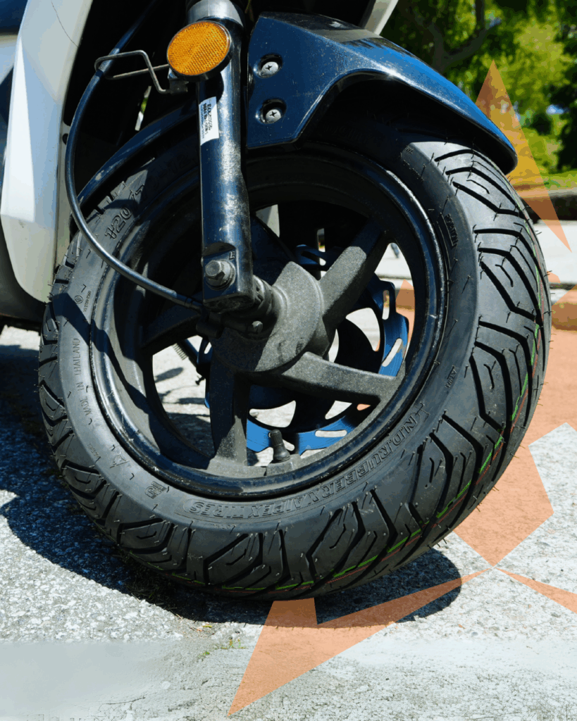 Aipex City scooter tire 120/70-12 on the front wheel of a Vespa close up.